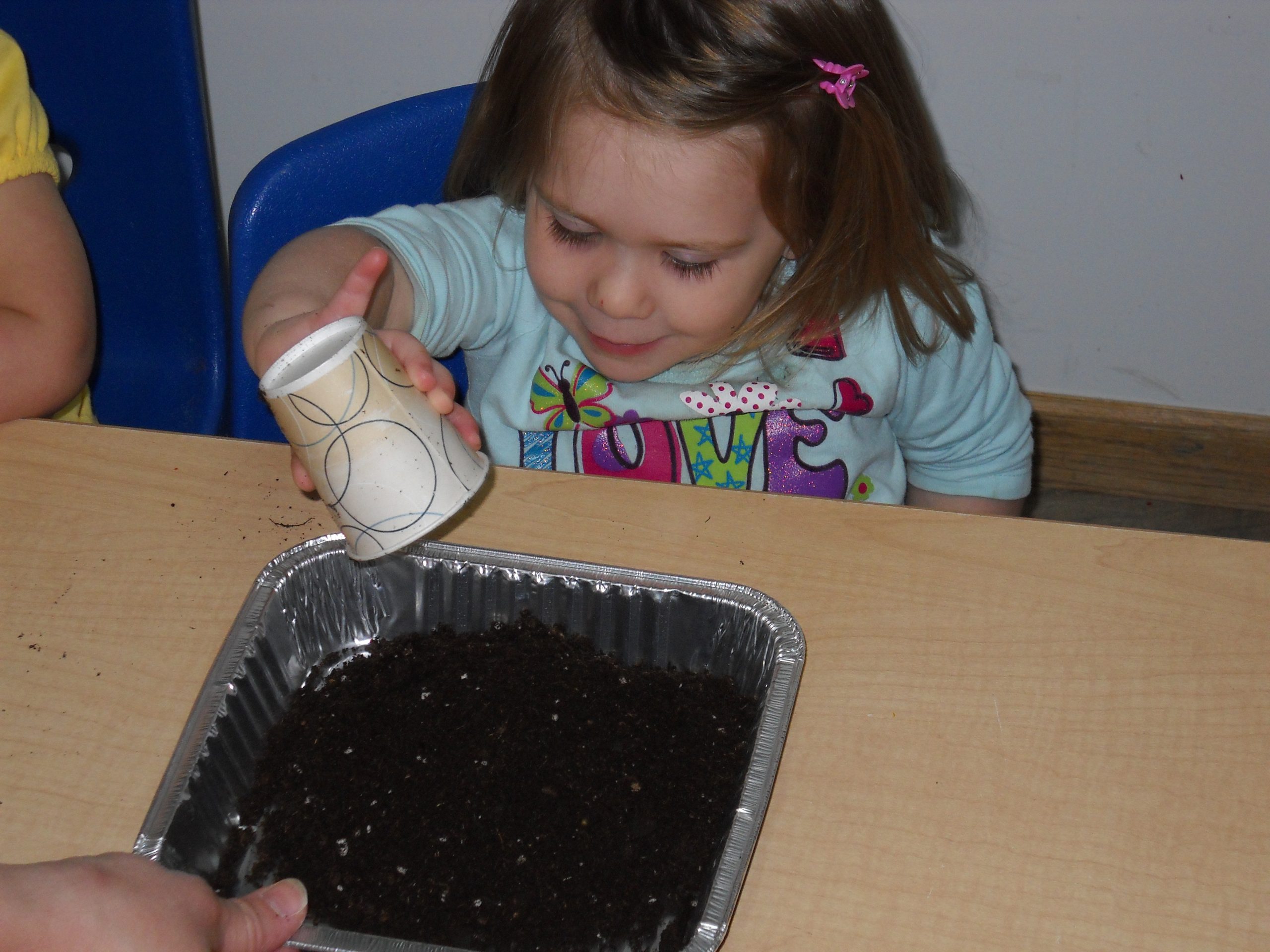 A child exploring soil during a hands-on classroom activity