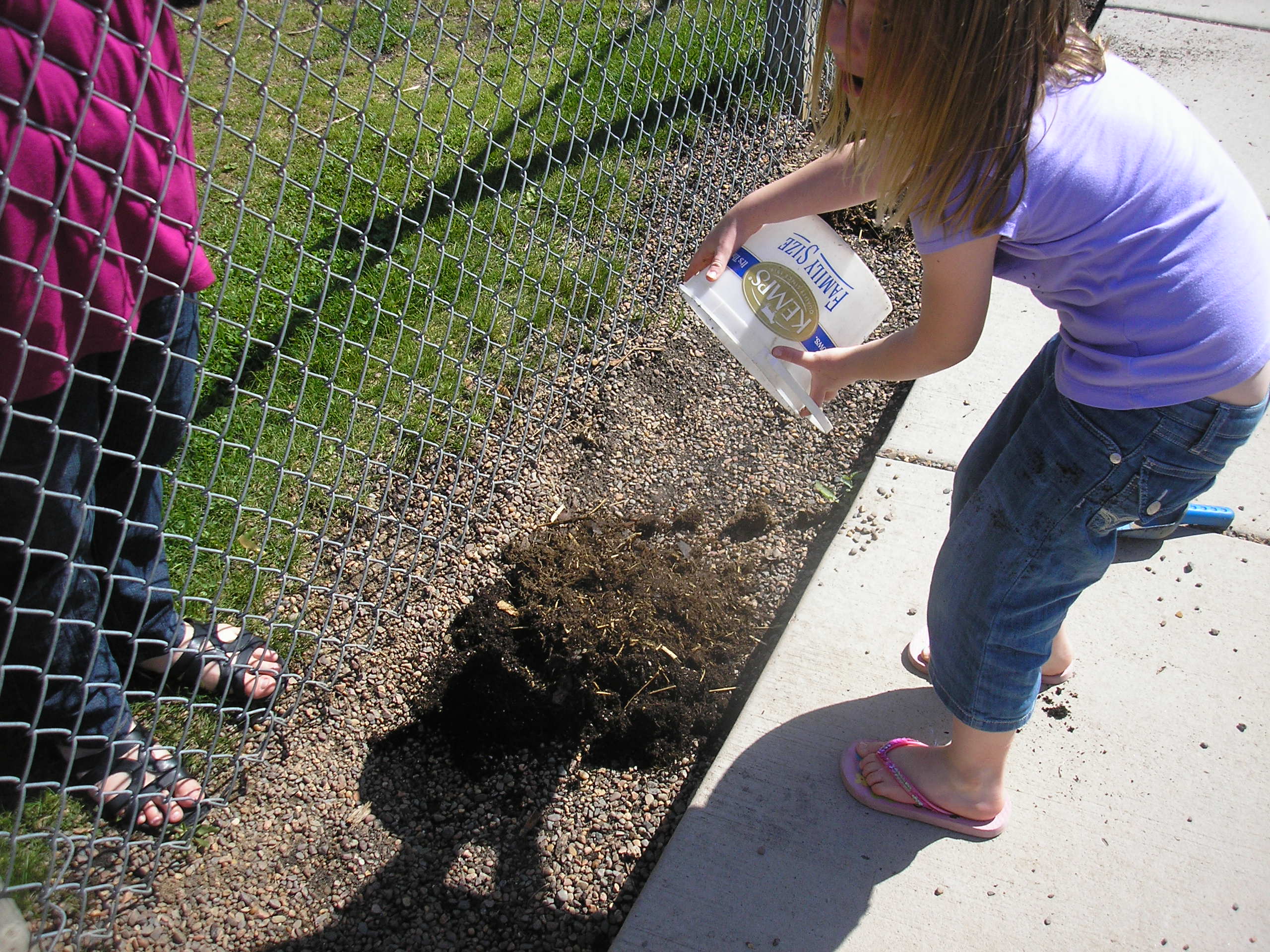 A child independently planting outdoors